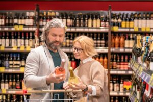 Customers reading label of wine making sure it's not counterfeit